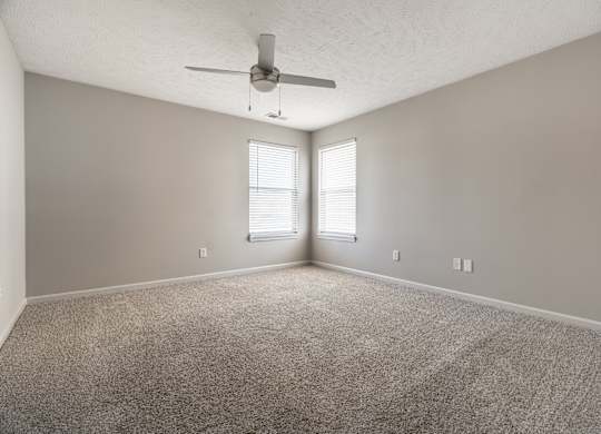 A room with a ceiling fan and carpeted floor at Mallard Bay Apartments, Crown Point, Indiana