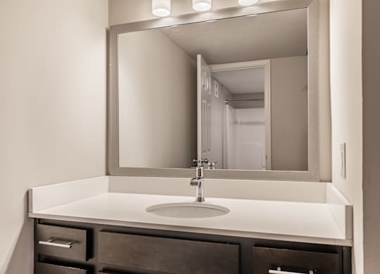 A bathroom sink with a large mirror above it at Mallard Bay Apartments, Crown Point, Indiana