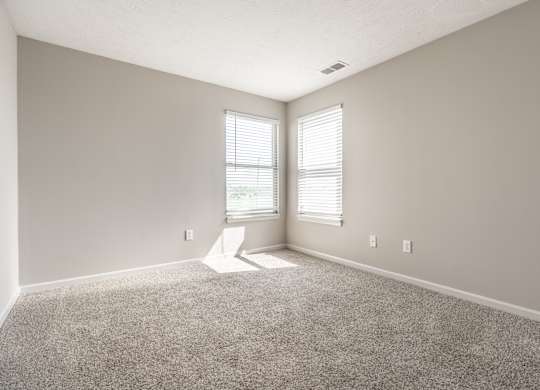 A room with a carpet floor and a window with blinds at Mallard Bay Apartments, Crown Point, Indiana