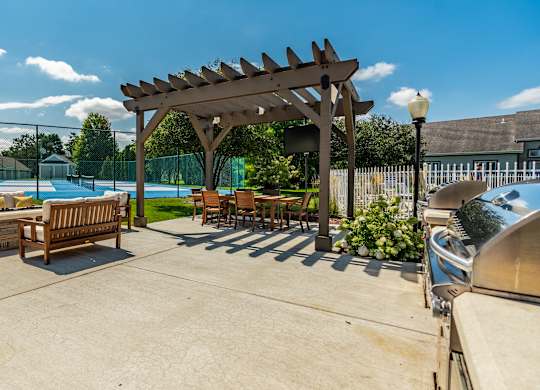 A sunny day at the poolside with a wooden pergola and lounge chairs at Mallard Bay Apartments, Crown Point, Indiana