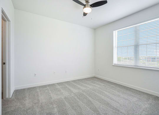 a bedroom with a ceiling fan and a window at Meadowbrooke Apartment Homes, Grand Rapids, 49512