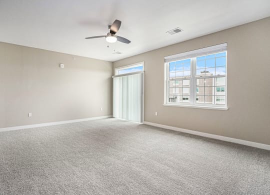 an empty bedroom with a ceiling fan at Meadowbrooke Apartment Homes, Michigan