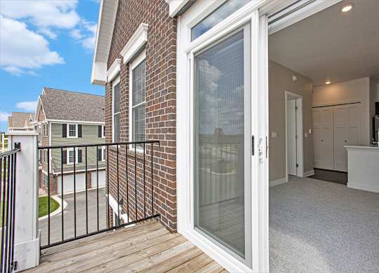 A glass door leading to a private balcony at Meadowbrooke Apartment Homes in Kentwood, MI 49512