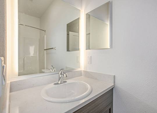 A bathroom with a white sink and a mirror above it at Meadowbrooke Apartment Homes in Kentwood, MI 49512