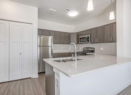 A kitchen with a breakfast bar at Meadowbrooke Apartment Homes in Kentwood, MI 49512