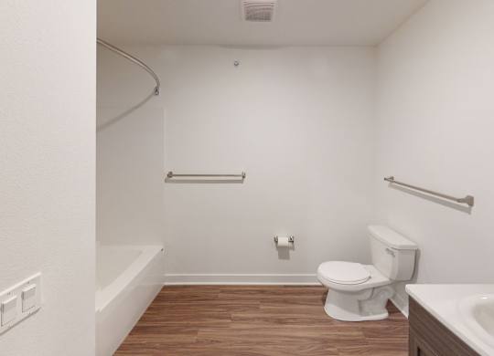 A bathroom with a toilet, sink and bathtub at Meadowbrooke Apartment Homes in Kentwood, MI 49512
