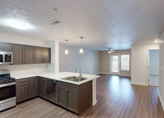 A kitchen and living room with hard surface floors at Meadowbrooke Apartment Homes in Kentwood, MI 49512