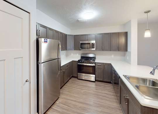 A modern kitchen with stainless steel appliances at Meadowbrooke Apartment Homes in Kentwood, MI 49512