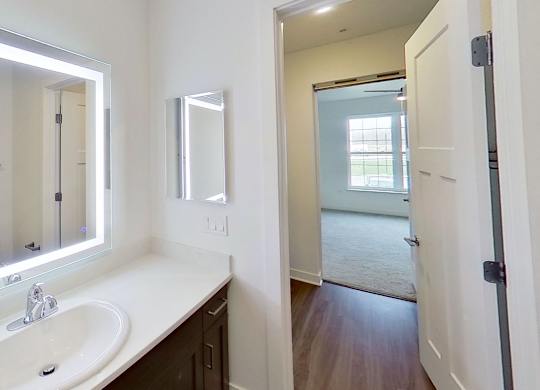 A bathroom with a sink and lighted mirror at Meadowbrooke Apartment Homes in Kentwood, MI 49512