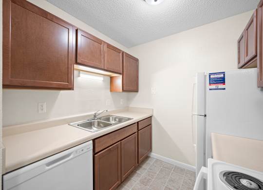 A small kitchen with a white dishwasher and a white refrigeratork at Timberlane Apartments, Peoria, Illinois