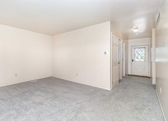 An entryway and living room with a carpeted floor at Mount Royal Townhomes, Michigan