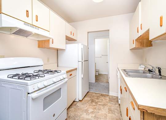A kitchen with a white stove and dishwasher at Mount Royal Townhomes, Michigan