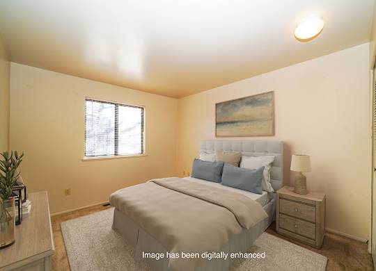 A bedroom with a large bed and a window at Mount Royal Townhomes in Kalamazoo, Michigan