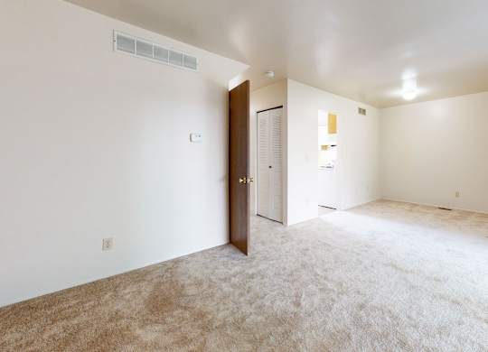 A living and dining room with a carpeted floor at Mount Royal Townhomes, Kalamazoo, MI