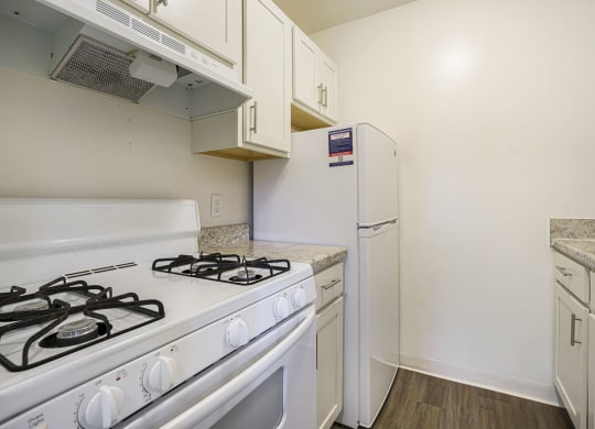 a white kitchen with hard surface flooring at Newport Village Apartments, Portage, MI