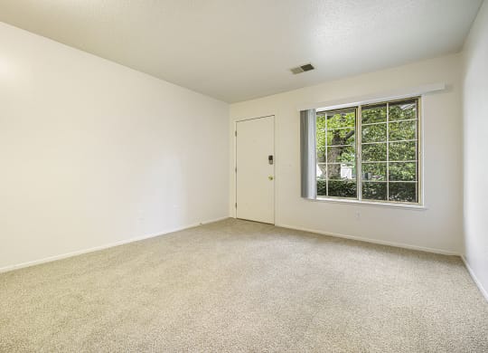 Main floor living with a large window at Newport Village Apartments, Portage, MI