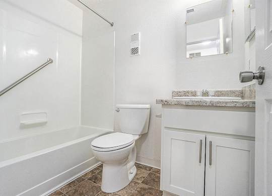 An upgraded bathroom with a bathtub and shower at Newport Village Apartments, Portage, MI