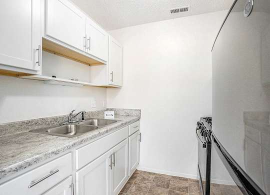 A kitchen with white cabinets and stainless steel appliances at Newport Village Apartments, Portage, MI