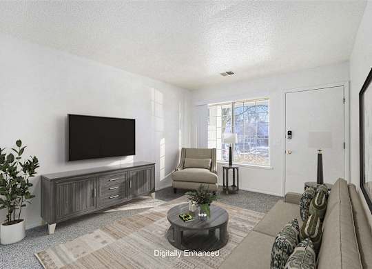 A living room with a flat screen TV, a sofa, and a coffee table at Newport Village Apartments, Portage, MI