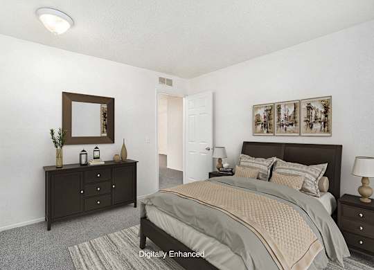 A bedroom with a bed, dresser, and mirror at Newport Village Apartments, Portage, MI