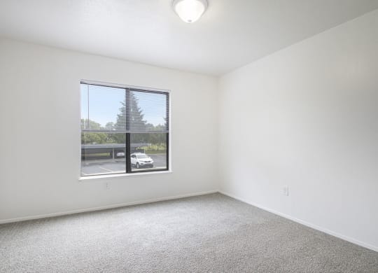an spacious bedroom with a large window and carpeting at North Pointe Apartments in Elkhart, IN