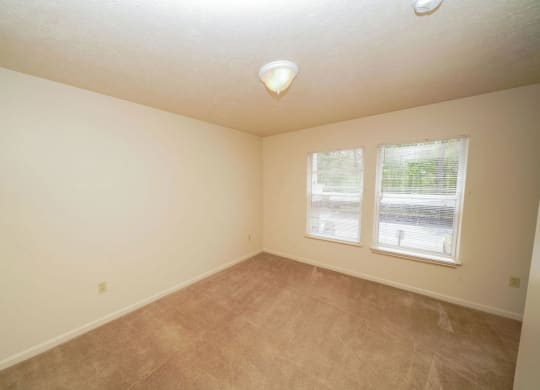a bedroom with carpet and two windows at North Pointe Apartments, Elkhart, IN