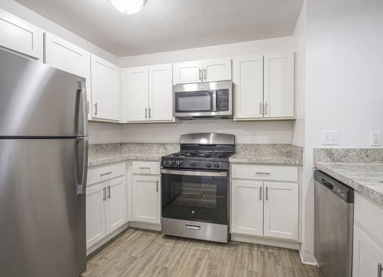 a kitchen with stainless steel appliances and white cabinets at North Pointe Apartments in Elkhart, IN