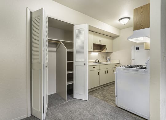 a kitchen with white appliances and a closet at Normandy Village Apartments, Michigan City