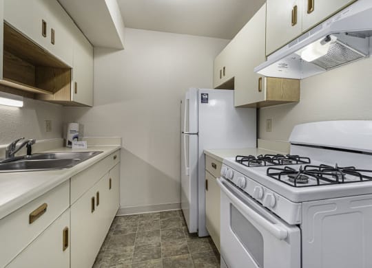 Galley kitchen with a stove and refrigerator and a sink at Normandy Village Apartments, Indiana, 46360