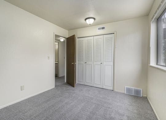 Bedroom with a large window and closet at Normandy Village Apartments, Indiana, 46360
