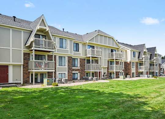 A large apartment building with balconies and red doors at Normandy Village Apartments in Michigan City, IN