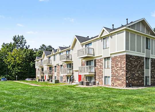 Apartment building with a green lawn in front at Normandy Village Apartments in Michigan City, IN