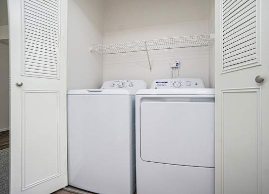 A washing machine and dryer in a small laundry room at North Pointe Apartments in Elkhart, IN