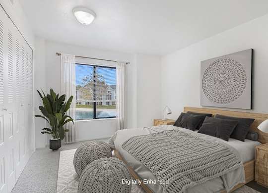 A bedroom with a large bed and a large window with a view at North Pointe Apartments, Elkhart