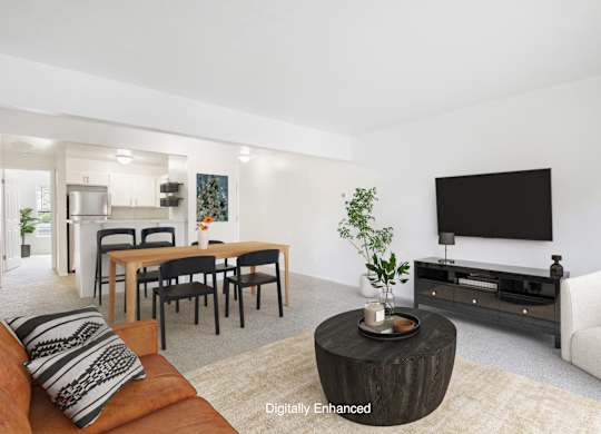 A modern living room with a wooden coffee table and a flat screen TV at North Pointe Apartments, Elkhart