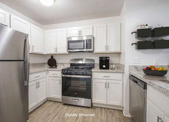 A kitchen with white cabinets and a stainless steel appliances at North Pointe Apartments, Elkhart