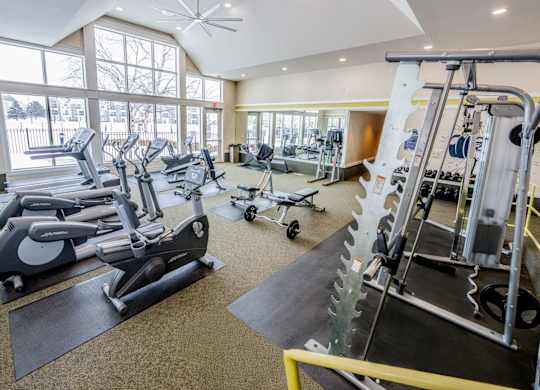 A gym with a variety of equipment including treadmills, stationary bikes, and weight machines  at Northport Apartments, Macomb, MI, 48044