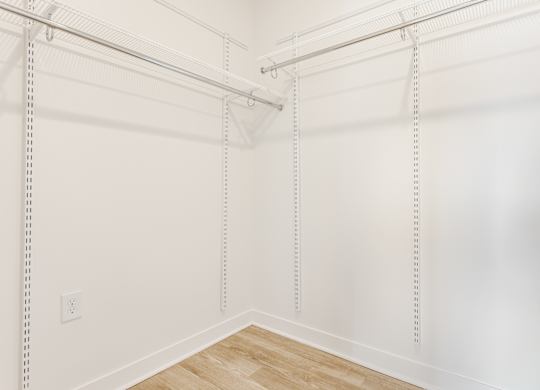 A white wall with a wooden floor and a white ceiling with a white pipe at Nuvo Flats, Indiana, 46410