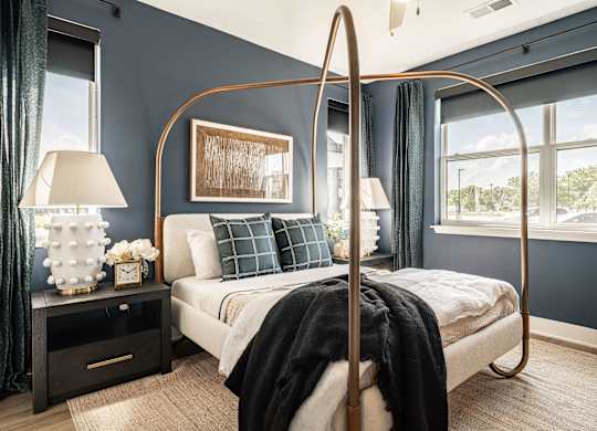 A bedroom with a four poster bed and a window.