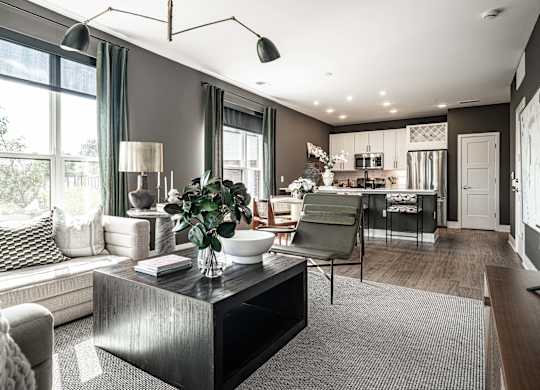A modern living room with a large window and a grey sofa.
