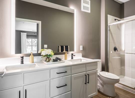 A bathroom with a white sink and a white toilet.