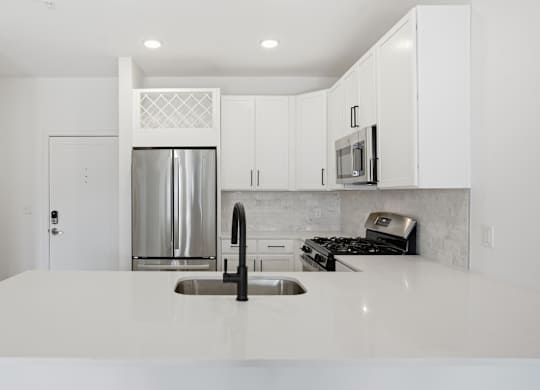 A modern kitchen with white cabinets and appliances at Nuvo Flats, Indiana, 46410