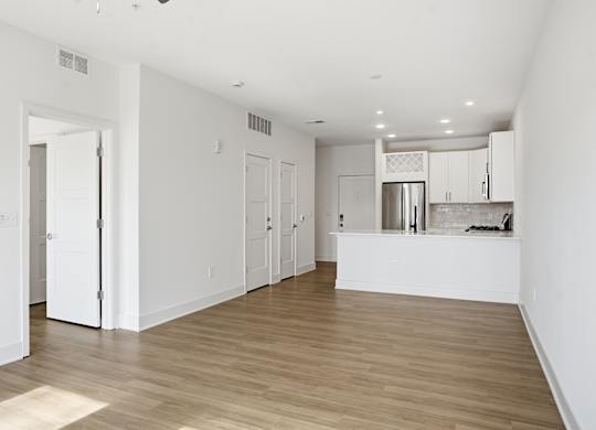 A kitchen area with white cabinets and a wooden floor at Nuvo Flats, Indiana, 46410