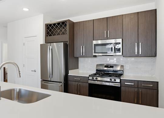 A modern kitchen with a stainless steel refrigerator, microwave, and oven at Nuvo Flats, Indiana, 46410