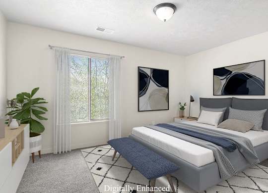 A bedroom with a large bed and a window with curtains at Old Farm Apartments, Elkhart, Indiana