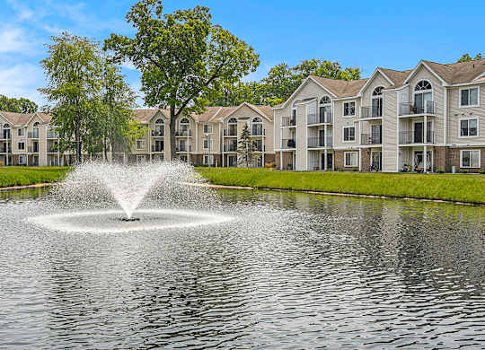 A fountain in the middle of a pond in front of apartment buildings at Orchard Lakes Apartments, Toledo, 43615