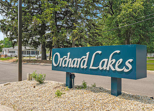 A sign that says Orchard Lakes with green trees behind it at Orchard Lakes Apartments, Toledo, 43615