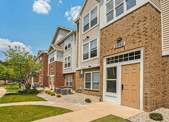 The front of an apartment building with green grass and sidewalks at Orchard Lakes Apartments, Toledo, 43615