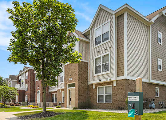 A large building with a pet waste station in front of it at Orchard Lakes Apartments, Toledo, 43615