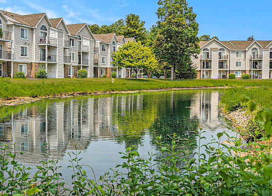 Apartment buildings are reflected in the water of a pond at Orchard Lakes Apartments, Toledo, 43615